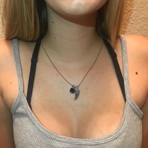 A blue charm and angel wing necklace